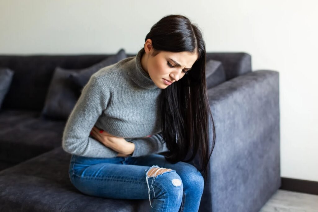 sick_woman_having_stomachache_living_room_1_10b3afb81b